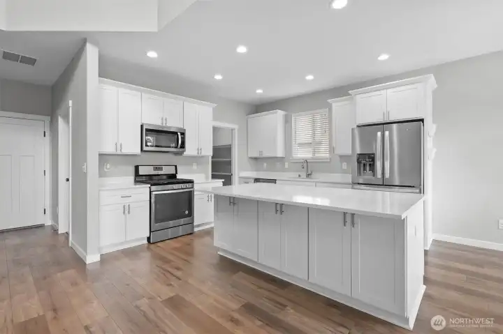 The kitchen features Whirpool appliances and a large walk in pantry.