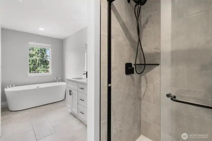 The primary bathroom also features a beautifully tiled shower and custom fixtures.