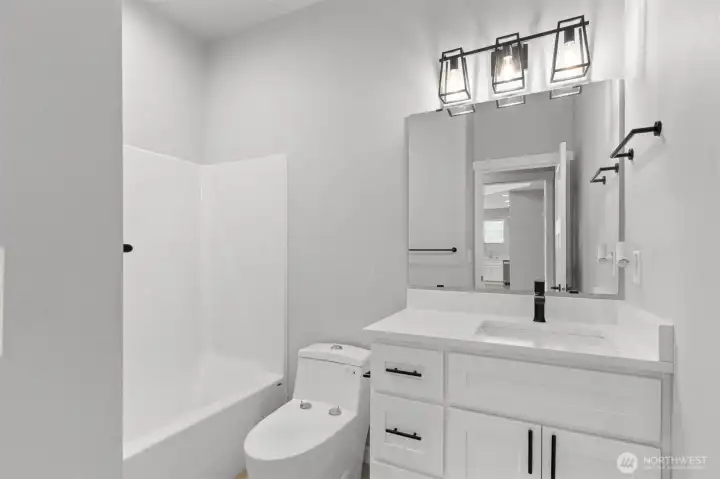 The lower full bathroom features beautiful counters, custom lighting, and a full tub and shower.