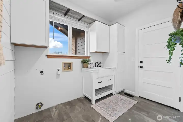 Light and bright with an essential laundry sink, storage, and garage access