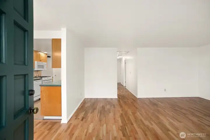 Gleaming hardwoods greet you after entering through the solid front door.  You are looking at the living room with the galley style kitchen to the left.