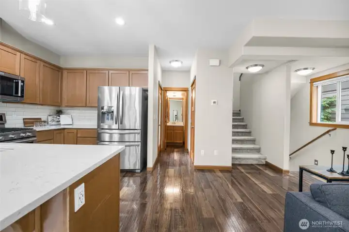 Kitchen is next to hallway and stairs