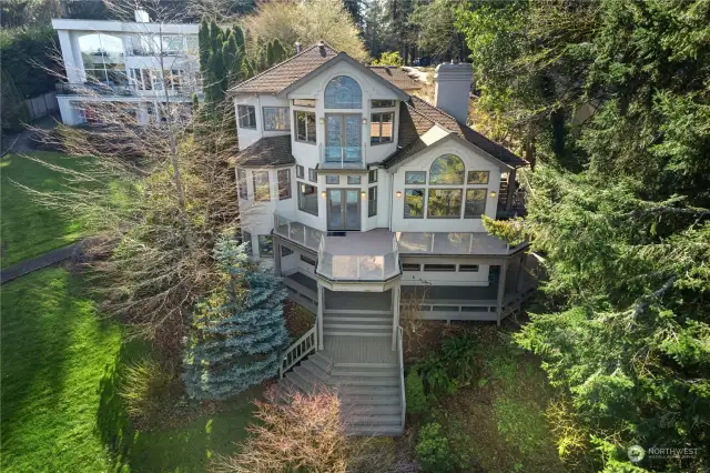 Fantastic views from nearly every room, turret holds the breakfast nook on the main floor and hot tub on the lower. Multi-level decks face North looking out at the water. Mature landscaping provides privacy.
