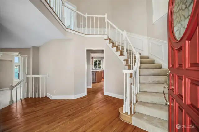 Entryway with warm wood floors and wainscoting walls.