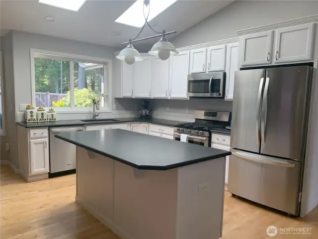Lots of natural light in kitchen, newer stainless appliances ,granite counter with island sitting area