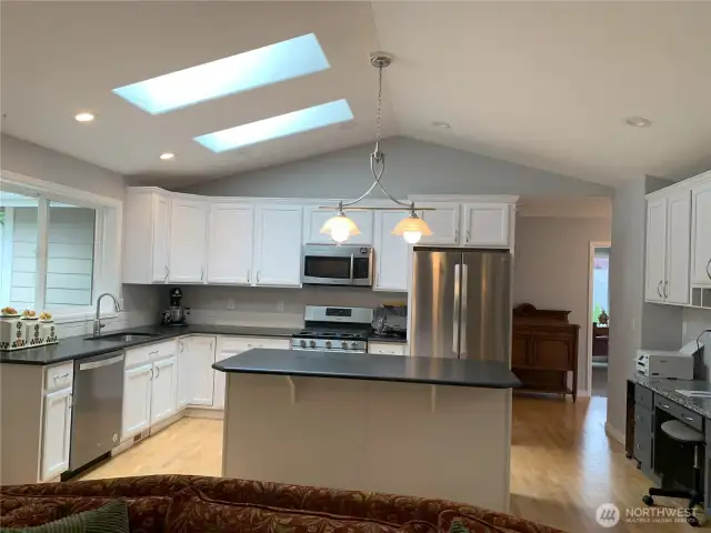 I love this kitchen. It has an expansive, hardwood floor and stainless appliances. It has granite countertops, too.  Gas cooktop