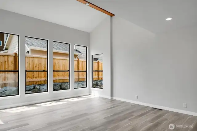 A wall of windows allows light to flood into this spacious living room.
