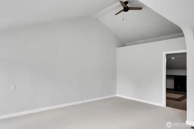 The vaulted ceiling in one section of the primary bedroom enhances the sense of space. Door leads to the spacious closet.