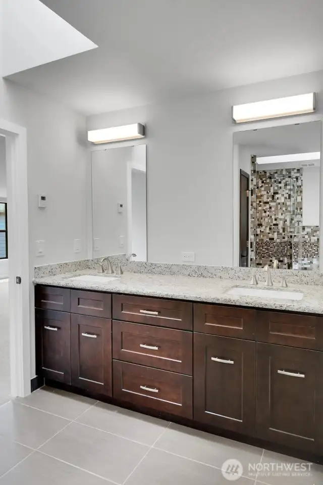 The primary bathroom also features a double vanity with ample storage space.