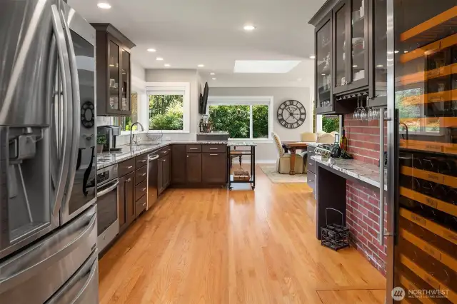Massive, bright kitchen, remodeled in 2020, with tons of cabinet and granite counters, new stainless appliances including two oven ranges, gas cooktop, large wine refrigerator, walk-in pantry, and large skylight.