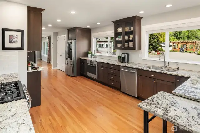 Massive, bright kitchen, remodeled in 2020, with tons of cabinet and granite counters, new stainless appliances including two oven ranges, gas cooktop, large wine refrigerator, walk-in pantry, and large skylight.