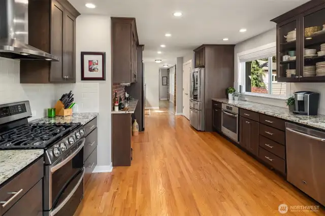 Massive, bright kitchen, remodeled in 2020, with tons of cabinet and granite counters, new stainless appliances including two oven ranges, gas cooktop, large wine refrigerator, walk-in pantry, and large skylight.