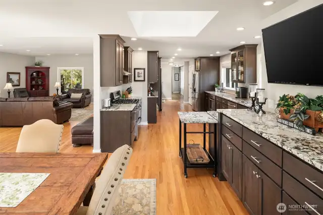 Massive, bright kitchen, remodeled in 2020, with tons of cabinet and granite counters, new stainless appliances including two oven ranges, gas cooktop, large wine refrigerator, walk-in pantry, and large skylight.