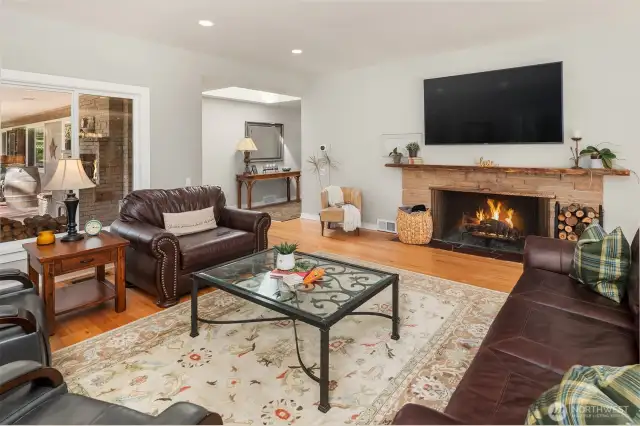 Coming back in from the patio to the family room framed by the wood-burning fireplace.
