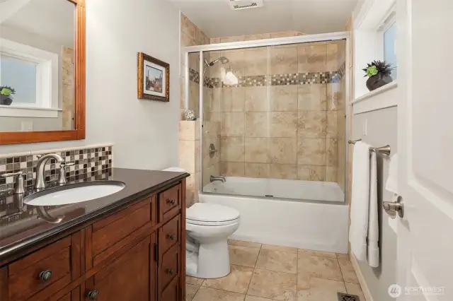 The remodeled main/guest bathroom with extensive tile-work.