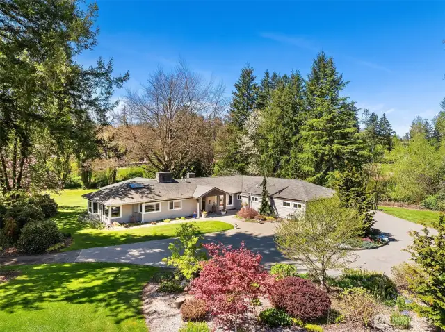A circular stone paver driveway with parking for 8 cars greets you at the entry.