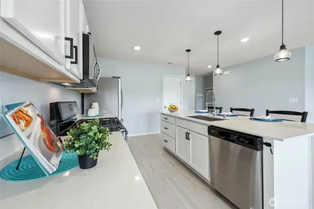 Note the quartz counters, Stainless steel appliances, and large pantry tucked under the stairs!