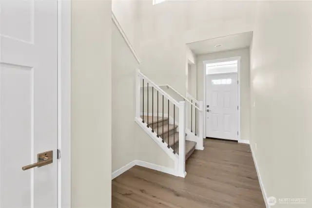 Inviting entry with hardwood flooring and vaulted ceilings.