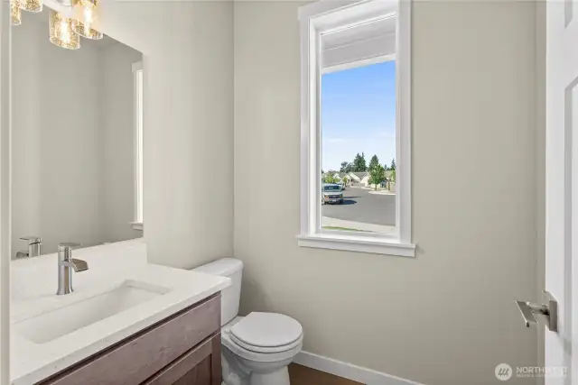 Half bathroom/ powder room in the main level with quartz countertops, backsplash and undermount sink.