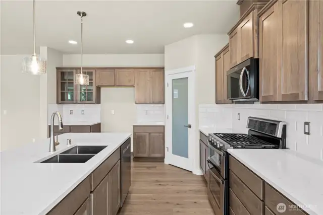 Kitchen with Shaker style Cocoa-stained Maple cabinets, stainless appliances, walk-in pantry, quartz counters, full tile backsplash. See cabinet color on next slide.