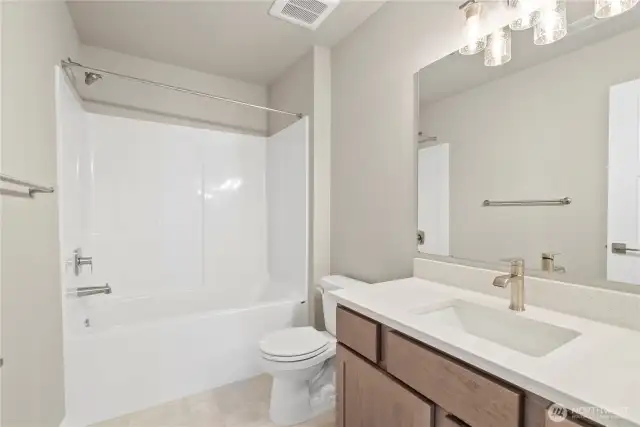 Main bathroom upstairs with undermount sink, contemporary fixtures, quartz countertop and tub/shower.
