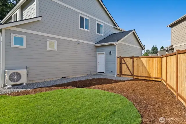 Fully fenced yard with side gate for exterior access and convenient service door to the garage.
