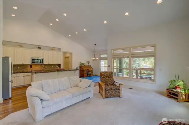 In the living room looking towards the kitchen, dining room and hallway to the primary suite and laundry room. There is a covered porch off the dining room. This home is available partially furnished.