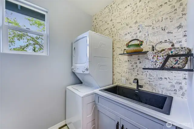 Efficient laundry room with a large sink and new cabinet.