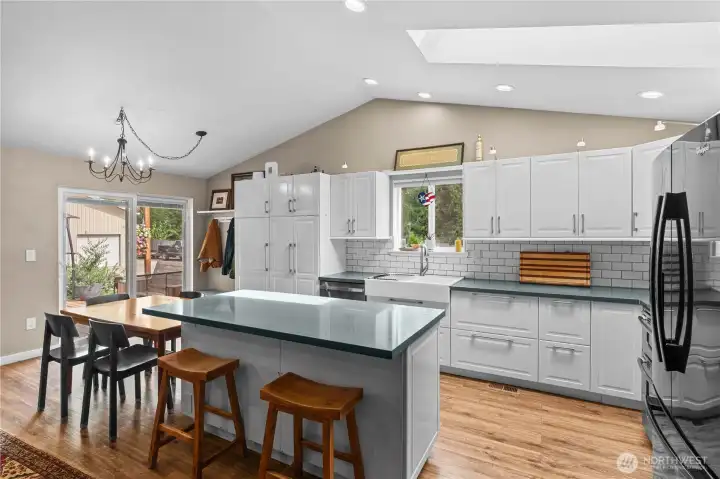 Updated Kitchen w/White Cabinets, Stainless and Black Appliances, Quartz Counters and Tile Backsplash. Island sits 2 - very convenient for a breakfast spot!