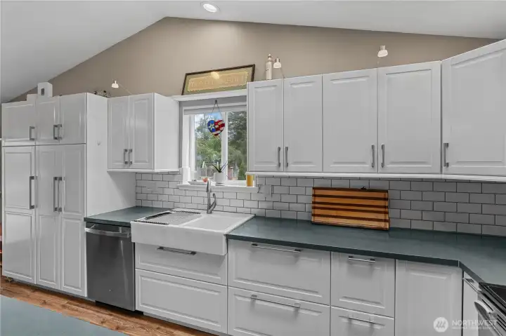 Under Cabinet Lighting, Farmhouse Sink, Oversized Pantry Cabinets and Window overlooking the yard.