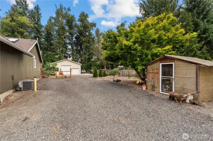 Driveway to the Shop. On the Right is the Greenhouse w/Power. Heat Pump on the Left.