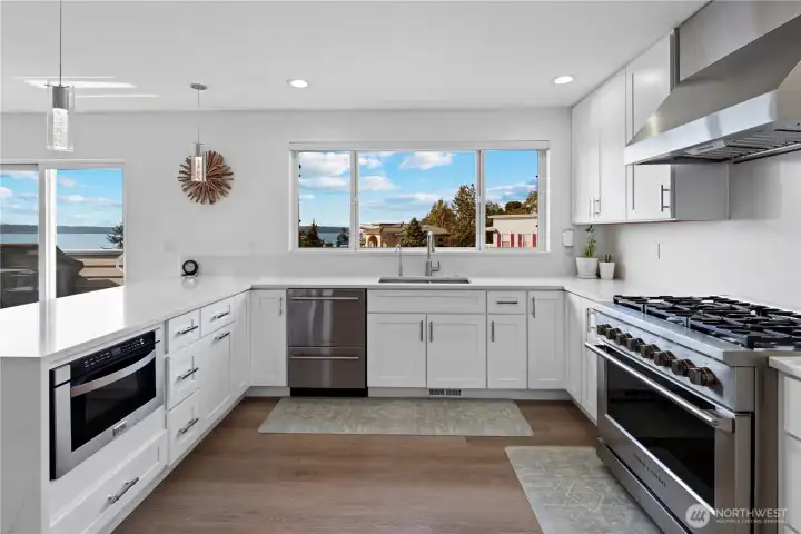 Dream Kitchen Remodel w/ new cabinets, quartz waterfall counters, a full-slab backsplash, pendant lighting, Fisher & Paykel appliances, a Zephr Pro-hood, built-in microwave