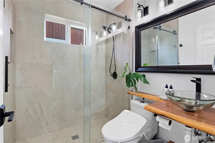 Originally a 1/2 bath, now a beautifully tiled 3/4 for the upstairs guest room