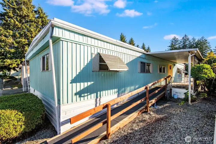 Side view showcases the covered entry, garden walkway, and low-maintenance setting designed for relaxed living.