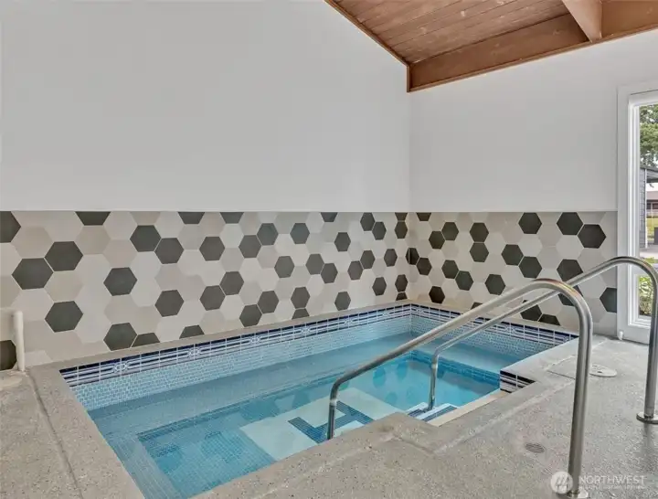 Soothe your muscles in the indoor hot tub, surrounded by stylish hexagonal tile and natural light.