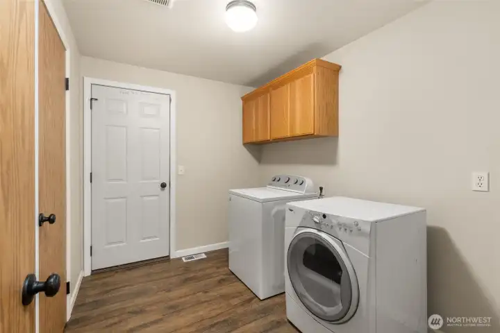 Oversized laundry room off entry, with access to garage and 1/2 bath