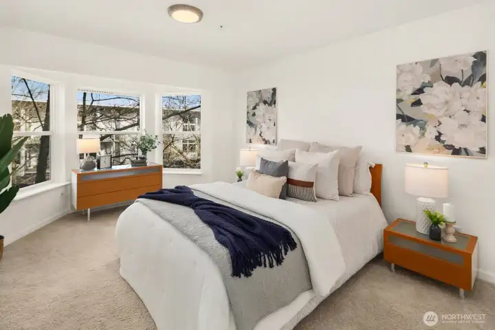 Spacious primary bedroom with bay window and dedicated custom closet area