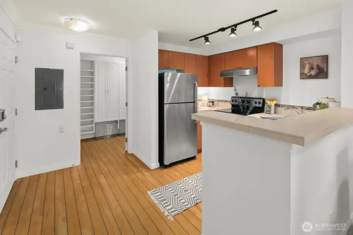 Entryway with view of the kitchen and in-unit laundry/storage roon