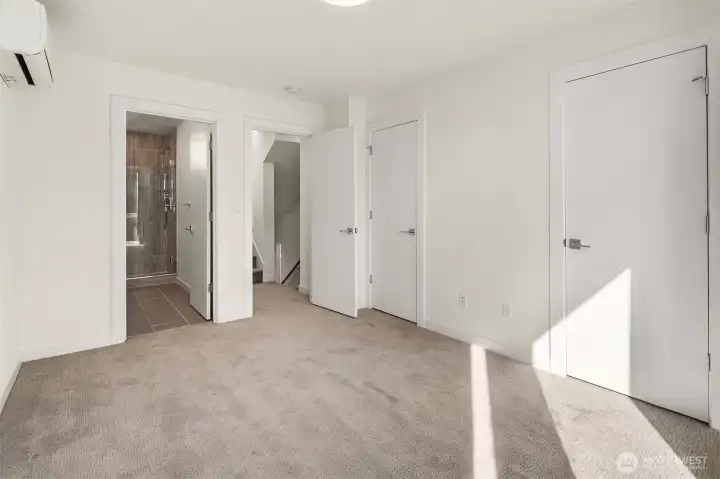 Primary bedroom with ensuite bath and two closets providing ample storage.