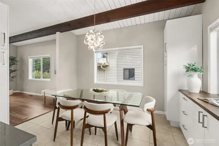 Bright and airy, this dining space is great for smaller crowds, and the open layout leaves room to expand your table on those days when everyone is here! Don't miss the coffee bar to the right - convenient countertop ports allow cords to run down and plug into outlets inside the cabinets, so it's always looking sleek.