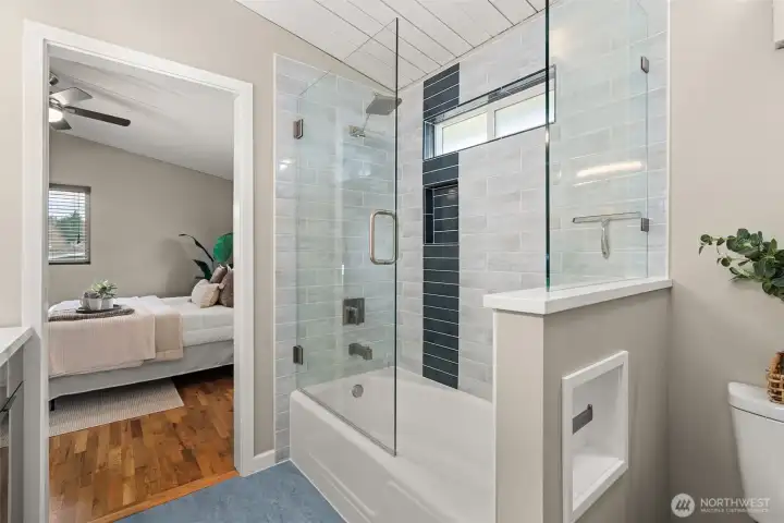 Fabulous tiled tub shower with contemporary hardware and window for added light/ventilation.