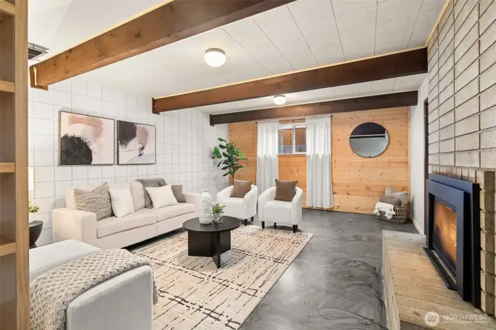Lower level features another large gathering space with wood wall, painted concrete floors, beamed ceilings and a beautiful 2 yr old gas fireplace. Just to the left of this photo you'll see big custom shelving unit, and to the right past the fireplace is a bedroom.