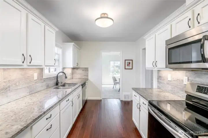 Kitchen leading into dining room.  All appliances convey. The laundry room is on the backside of this view.
