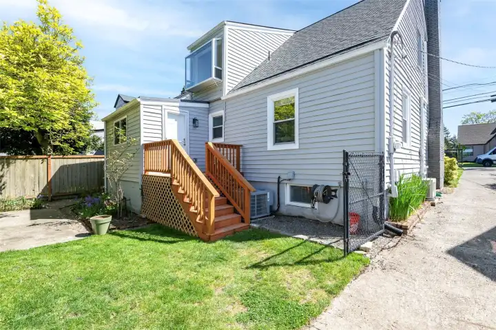 Rear exterior deck, back door lawn area.   Mature landscaping surrounds the home with established trees, shrubs, and seasonal blooms. Relax on the back patio under a green canopy all summer next to the outdoor stone fire pit. A dry, semi-finished basement offers flexible rec room / home gym space with fresh flooring.    Fully fenced property with 6' privacy fencing in back and black chain-link fencing with a remote-controlled rolling gate at the front. Deep driveway offers multiple off-street parking spots and leads to newer 14’x24’ detached garage with an extra tall ceiling offering generous storage options and accommodation for tall vehicles.    Roof and side sewer u