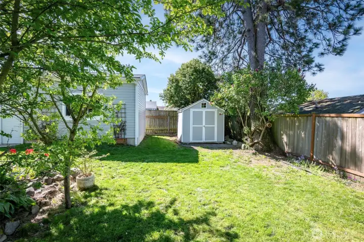 Fully fenced property. This is the backmost portion of your large lot.  This wood shed is in great condition and provides extra storage for outside equipment.   Mature landscaping surrounds the home with established trees, shrubs, and seasonal blooms. Relax on the back patio under a green canopy all summer next to the outdoor stone fire pit. A dry, semi-finished basement offers flexible rec room / home gym space with fresh flooring.    Fully fenced property with 6' privacy fencing in back and black chain-link fencing with a remote-controlled rolling gate at the front. Deep driveway offers multiple off-street parking spots and leads to newer 14’x24’ detached garage with an extra tall ceiling offering generous storage options and accommodation for tall vehicles.    Roof and side sewer u