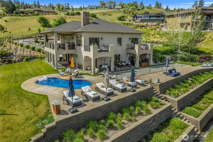 Resort-style outdoor living with pool, bocce ball court, patios and beautifully terraced landscaping