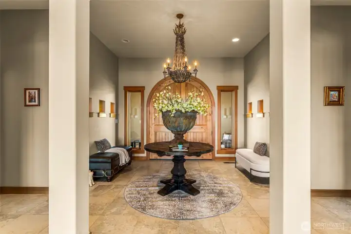 Elegant entry with soaring ceilings, timeless architectural detail, and built in lighted niches to display artwork