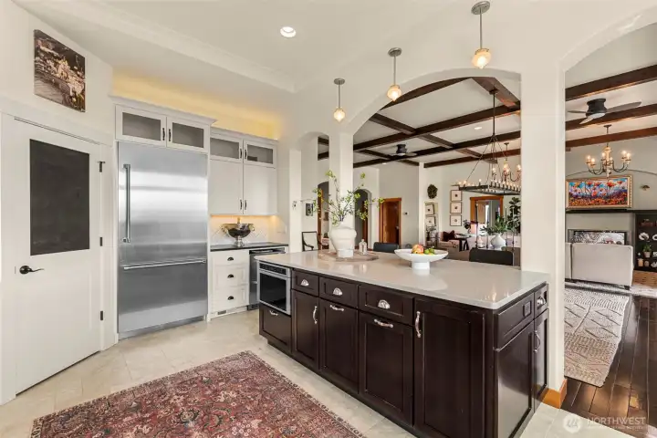 The gourmet kitchen features a walk-in pantry, premium Thermador appliances, and a stylish beverage station complete with a Vevor beverage cooler.