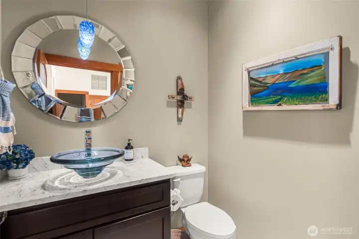Stylish powder bath featuring a statement mirror and artisan glass lighting