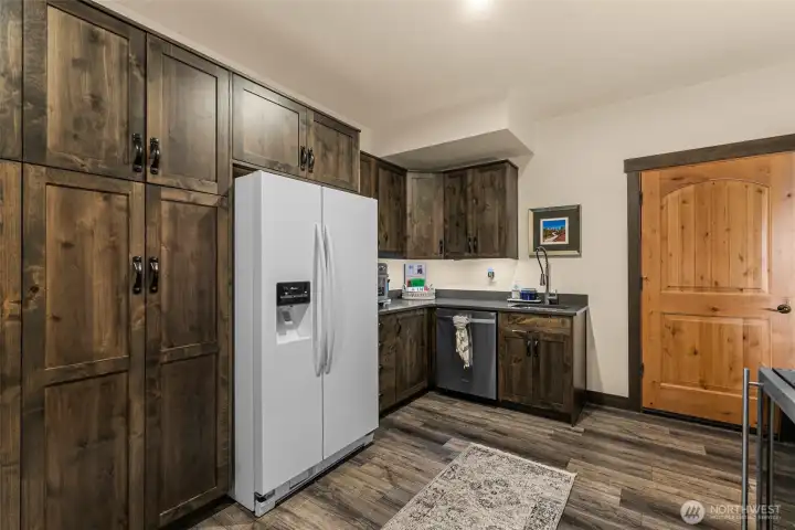 Just steps away from the family room is a convenient lower-level kitchenette with full-size refrigerator, sink, dishwasher, and abundant storage
